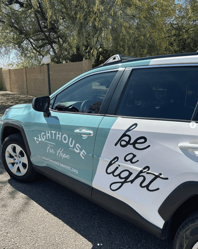 "Car with 'Lighthouse for Hope' and 'be a light' text.